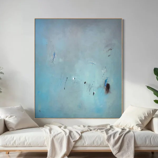 Large square blue abstract painting by PEZ styled above a neutral modern sofa in a bright, minimalist living room.